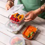 Świeże owoce w hermetycznym pojemniku na lunch, idealne do przechowywania i transportu zdrowych przekąsek.