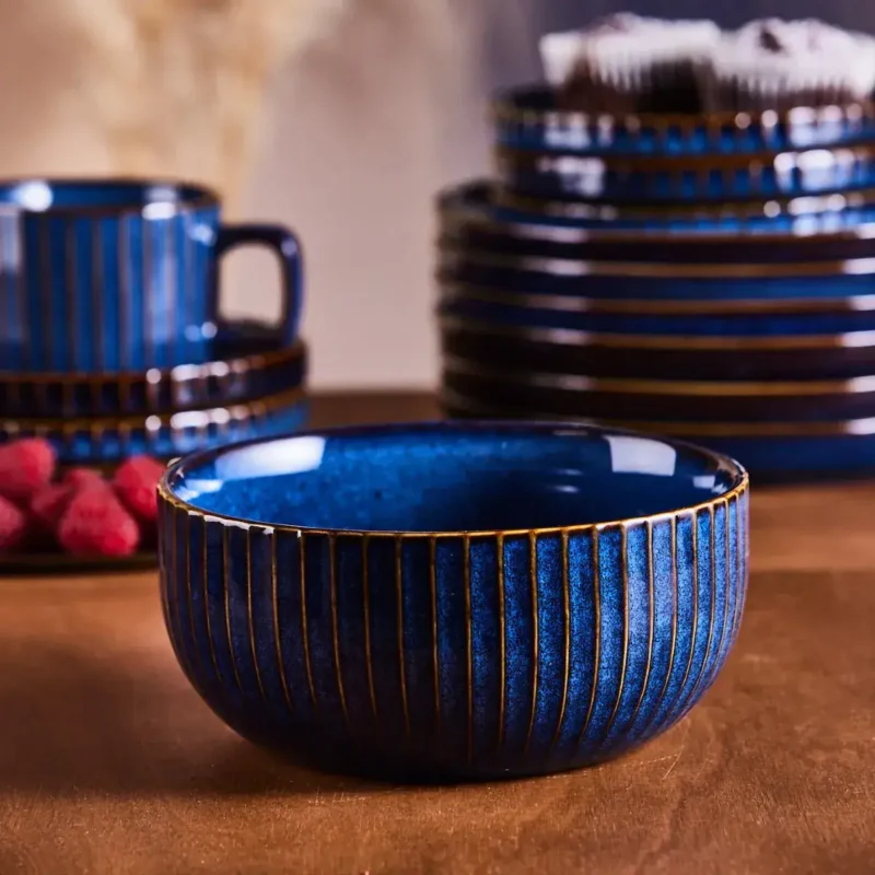 Misternie zdobiona niebieska miska ceramiczna z złotymi prążkami, idealna na codzienne obiady i dekoracje stołu w domu.