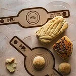 Miara do pieczenia i formowania ciasta na blacie kuchennym, na tle rozwałkowanego ciasta, rękawa cukierniczego i ciastek, w kuchni domowej, wygodne narzędzia kuchenne, pies do wypieków, melamina i silikon.