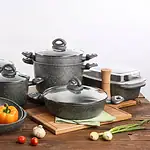 Komplet garnków z powłoką non-stick, czarna stonowana, na drewnianym stole, idealne do gotowania i pieczenia.