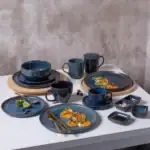 Elegancka zastawa stołowa w głębokim odcieniu niebieskiego, idealna do nowoczesnych wnętrz i eleganckich okazji, z złotymi detalami, inspirowana stylem Domowy Zakątek.