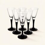 Szklanki do szampana z czarną podstawą i transparentnym kieliszkiem, elegancki zestaw na specjalne okazje, idealny do serwowania napojów alkoholowych.