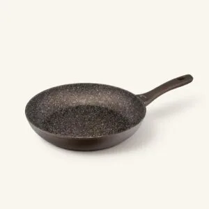Patelnia ceramiczna z czarnym wnętrzem i ergonomiczną rączką, idealna do smażenia i gotowania na kuchni.