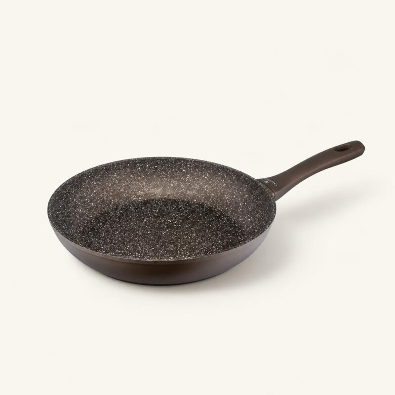 Patelnia ceramiczna z czarnym wnętrzem i ergonomiczną rączką, idealna do smażenia i gotowania na kuchni.