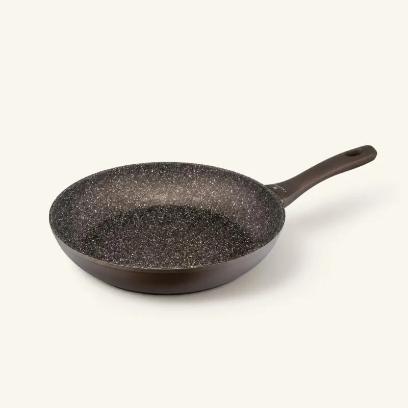 Patelnia ceramiczna z czarnym wnętrzem i ergonomiczną rączką, idealna do smażenia i gotowania na kuchni.