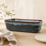 Duży, elegancki ceramiczny półmisek w odcieniach niebieskiego i szarego, idealny do serwowania potraw na stole, na tle jasnej powierzchni i delikatnych elementów dekoracyjnych.